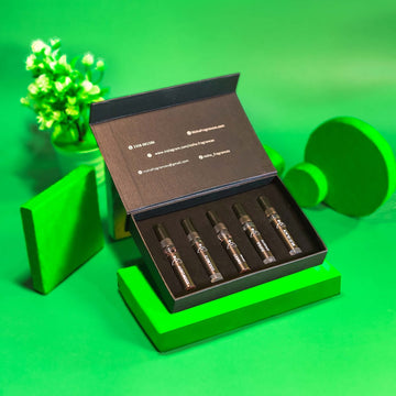 Open black box containing ampoules on a green background