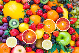 Assorted fruits including apples, oranges, bananas, and berries on a colorful background